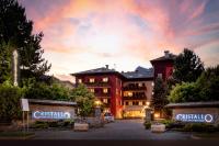a hotel with a parking lot in front of a building at Hotel Cristallo in Bormio