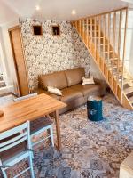 a living room with a couch and a staircase at Gîte « Le Patio » in Montfarville