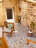 a living room with a stone fireplace and a chair at Gîte « Le Patio » in Montfarville