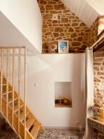 a staircase in a room with a stone wall at Gîte « Le Patio » in Montfarville