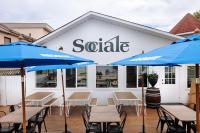 een terras met tafels en parasols voor een verkoopgebouw bij Kettle Valley Beach Resort in Penticton