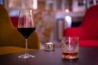 メリニャックにあるLe M & Spa Bordeaux Aéroport by Hôtels & Préférenceのアルコールのグラスの隣にワインのグラスが置かれている