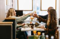eine Gruppe von Menschen sitzt um einen Tisch herum und isst in der Unterkunft Novotel Den Haag City Centre in Den Haag