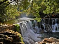 a waterfall in the middle of a river at Cabane et potager sud Cévennes, jacuzzi en option in Roquedur