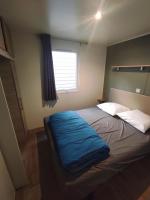 a bedroom with a bed with a blue blanket on it at Family&#39;s Camping Le Savoy in Challes-les-Eaux