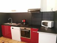 a small kitchen with red cabinets and a microwave at Desix 