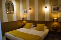 a bedroom with a large bed with two yellow pillows at Hôtel Saint Albert in Sarlat-la-Canéda