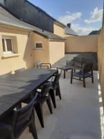 a large wooden table and chairs on a patio at Le Rêve de Marcel in Le Molay-Littry