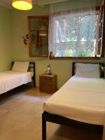 a bedroom with two beds and a window and a table at Evak Chalet in Paleo Tsifliki
