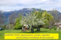 a flowering tree in a yard with mountains in the background at Le Clos Du Berger in Le Sauze
