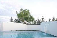a swimming pool with a white fence and a waterfall at Les Villas des Fontaines in Saumane-de-Vaucluse