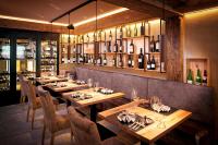een restaurant met houten tafels en stoelen en wijnflessen bij Chalet Resort Sölden in Sölden