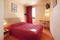 Una habitación de hotel con una cama roja y una ventana. en Premiere Classe Evreux, en Évreux