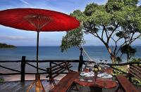 a picnic table with a red umbrella and the ocean at Banyan Bay Villas in Ko Jum