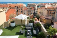 Habitación con vistas a un balcón con sombrilla y sillas. en Best Western Hotel Mediterranee Menton, en Menton