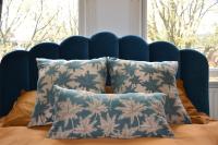 a bed with two pillows and a blue head board at Huize Maurits in The Hague