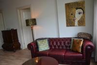 a living room with a red leather couch and a painting at Huize Maurits in The Hague