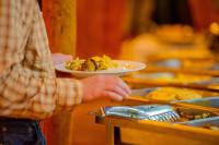 AkageraAkagera Transit Lodge的把一盘食物放在桌子上的人