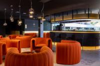 un restaurante con sillas naranjas y un bar en Hôtel Spa Restaurant Villa Castellane, en Gréoux-les-Bains