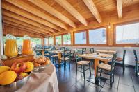 Hotel Bed & Bike Ledro في مولينا دي لادرو: مطعم بطاولات وكراسي وصحن فواكه