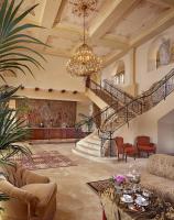 sala de estar con escalera y lámpara de araña en Ayres Hotel Manhattan Beach, en Hawthorne