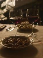 een bord eten op een tafel met twee glazen wijn bij Bed & Breakfast Casa Marinella in Lenna