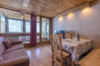 a dining room with a table and a couch at Résidence Le Sérac - Val Thorens in Val Thorens