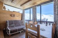 a room with a chair and a table and a window at Résidence Le Sérac - Val Thorens in Val Thorens