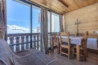 a dining room with a table and chairs and a large window at Résidence Le Sérac - Val Thorens in Val Thorens