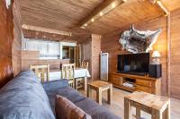 a living room with a couch and a tv at Résidence Le Sérac - Val Thorens in Val Thorens