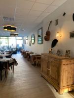 a dining room with tables and a guitar on the wall at LE PATIO in Millau