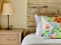 a bedroom with a wooden headboard and a bed with a lamp at SpoonDrift Hostal Kenting in Nanwan