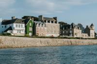 a group of houses next to a body of water at Hôtel Aux Tamaris - Vue Mer in Roscoff