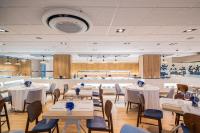 Un gran salón de banquetes con mesas y sillas. en Neptuno Hotel & SPA 4 Sup, en Calella