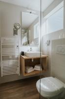 a bathroom with a sink and a toilet and a mirror at Hôtel Aux Tamaris - Vue Mer in Roscoff