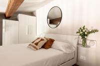 a white bedroom with a mirror and a bed at Florentia Art Apartments in Florence