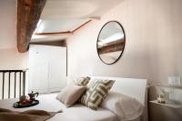 a bedroom with a bed with a mirror on the wall at Florentia Art Apartments in Florence