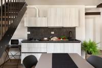 a kitchen with white cabinets and a black counter top at Florentia Art Apartments in Florence