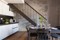 a dining room with a table and a staircase at Florentia Art Apartments in Florence