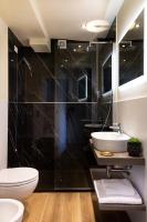 a black bathroom with a toilet and a sink at Florentia Art Apartments in Florence