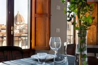 a table with two wine glasses and a vase at Florentia Art Apartments in Florence