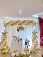 a gold and white balloon arch with a table at White Hotel in Hà Tĩnh