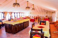 a room with a tent with tables and chairs at Relaxing Desert Camp in Merzouga