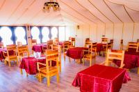 a dining room with tables and chairs in a tent at Relaxing Desert Camp in Merzouga