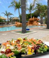 un plateau de salade sur une table à côté d'une piscine dans l'établissement Résidence & SPA Marina d'Arone, à Piana