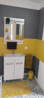 a bathroom with a white sink and a yellow wall at Studio neuf dans propriété au bord de la mer in Criel-sur-Mer