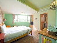 a bedroom with a bed and a table in it at Hejia B&amp;B in Hualien City