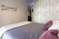 a bedroom with a bed with purple and white pillows at Appart cosy(4pers)PARKING CLIM Terrasse Vélodrome in Marseille