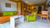 a living room with a couch and a table and chairs at Studios Bellevue in Charmey