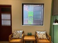 two benches in a room with a window at Shenten Homestay in Jincheng